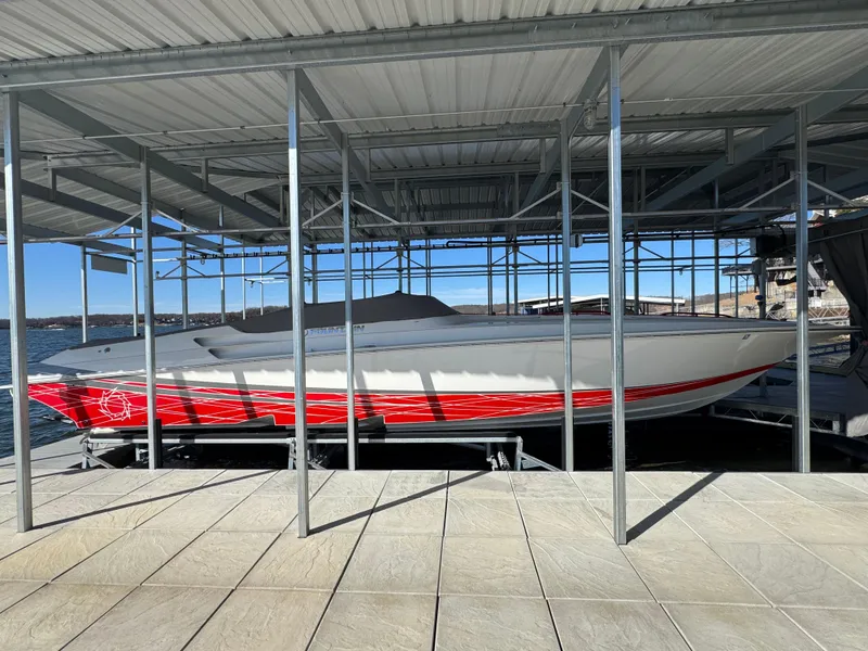 Slide: The Image of 2008 Fountain 38 Lightning boat with red accents docked under a covered structure. - 17