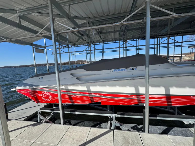 Slide: The Image of 2008 Fountain 38 Lightning boat with red accents docked under a metal canopy. - 18