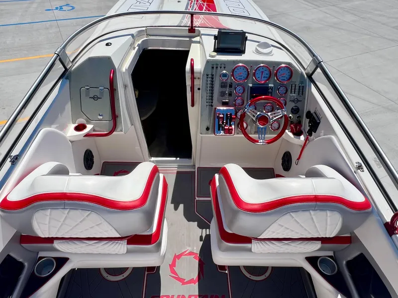 Slide: The Image of 2008 Fountain 38 Lightning boat interior with red and white seating, dashboard, and controls. - 20
