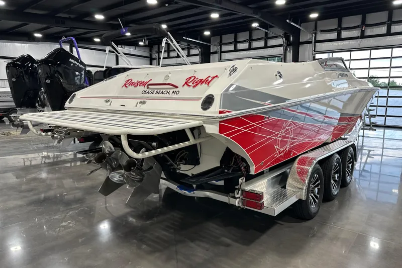 Slide: The Image of 2008 Fountain 38 Lightning boat with red and white design, displayed indoors on a trailer. - 3