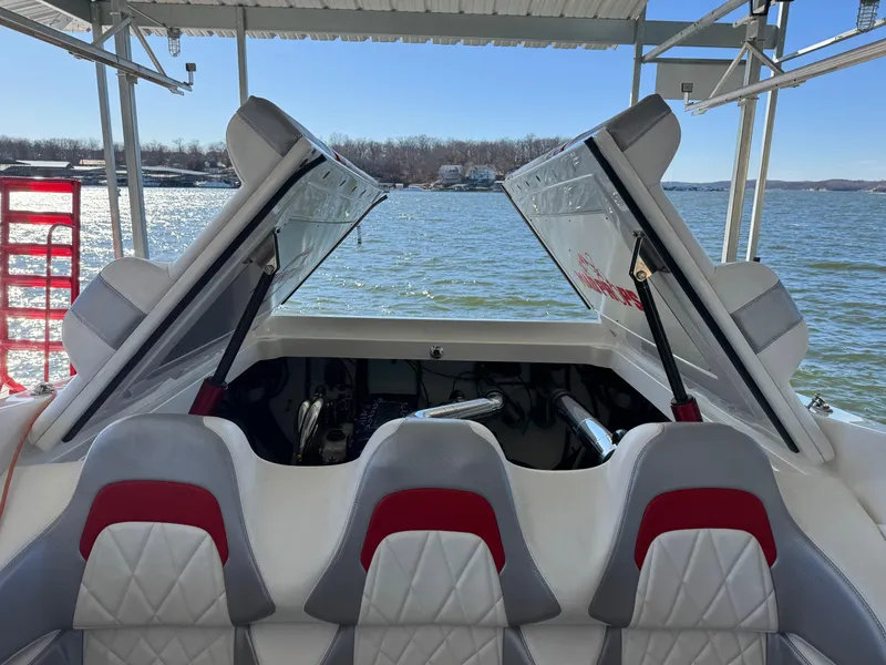 Slide: The Image of 2008 Fountain 38 Lightning boat interior with open engine hatch, docked by a lake. - 48