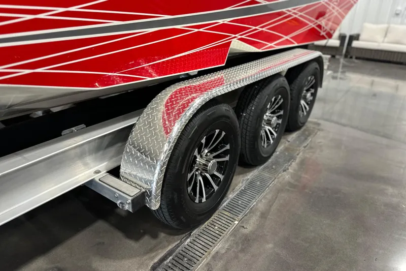 Slide: The Image of 2008 Fountain 38 Lightning boat on trailer with red and silver design, triple axle wheels. - 7