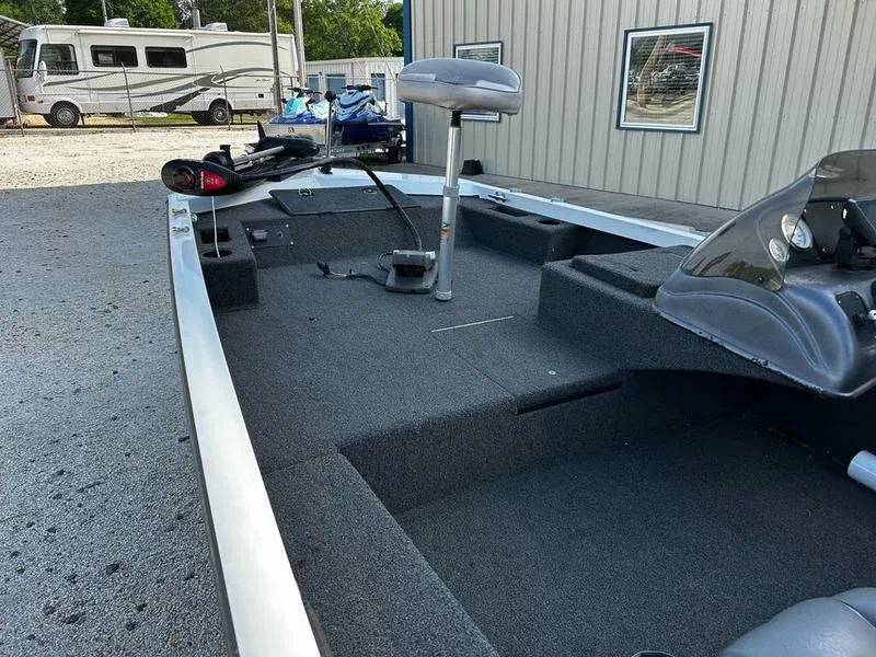 Slide: The Image of 2007 Triton TC-17 boat interior with fishing equipment, parked near a building. - 13