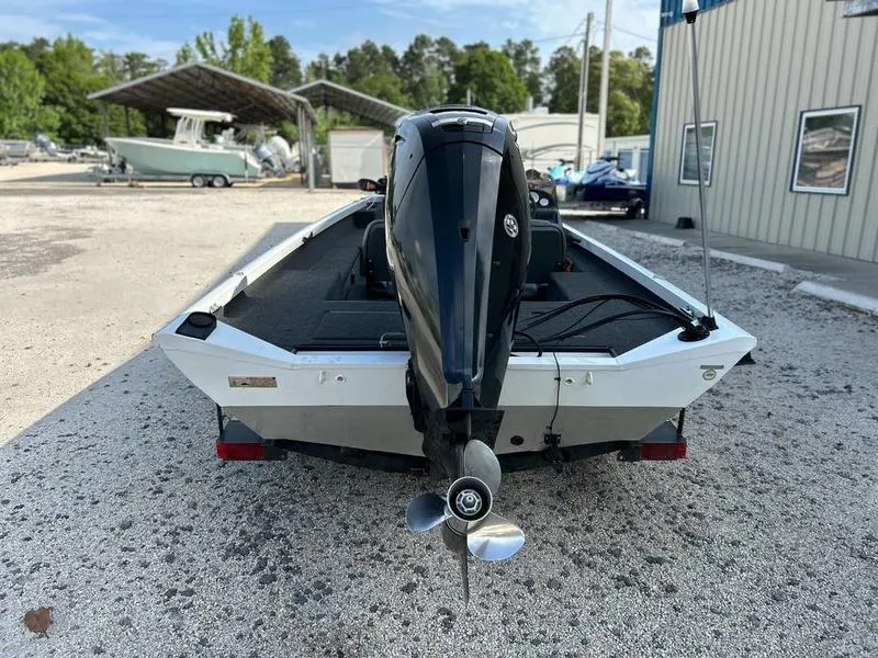 Slide: The Image of 2007 Triton TC-17 boat with outboard motor, parked on gravel near a building. - 8