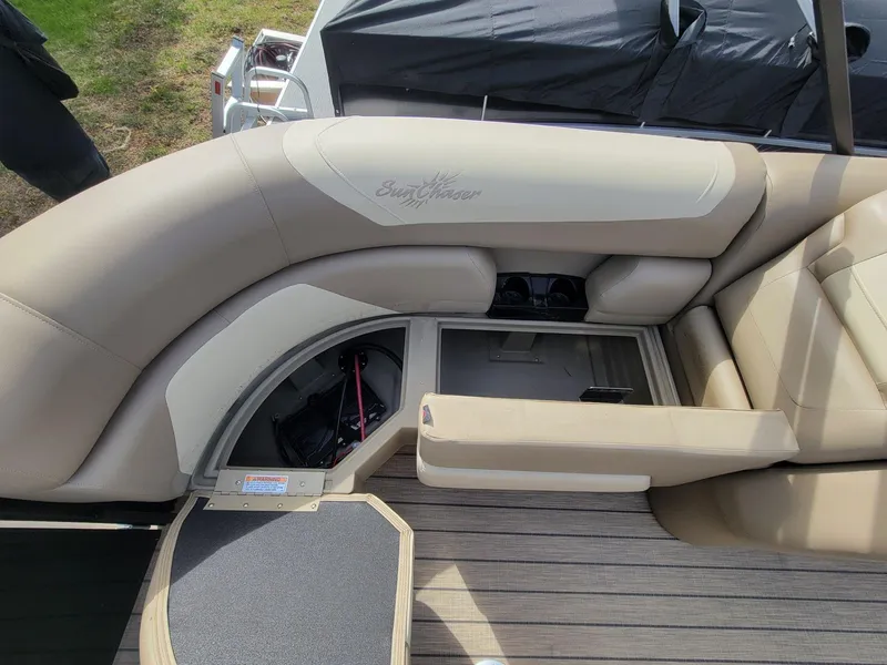 Slide: The Image of 2023 SunChaser Geneva Cruise 24 LR DH boat interior with beige seating and storage compartments. - 16