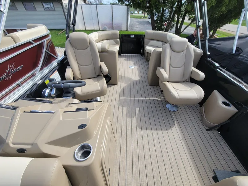 Slide: The Image of 2023 SunChaser Geneva Cruise 24 LR DH pontoon boat interior with beige seating and steering console. - 5