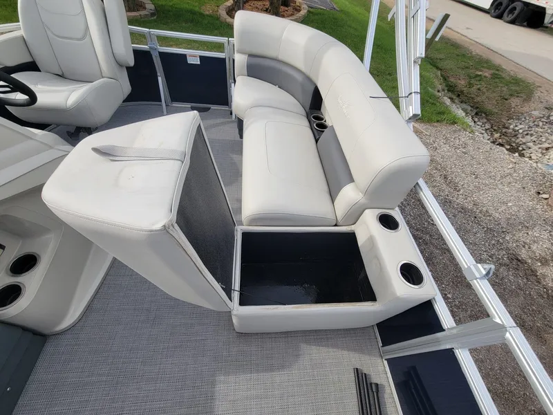 Slide: The Image of 2023 SunChaser Vista 16 Fish boat interior with open storage compartment and cup holders. - 12