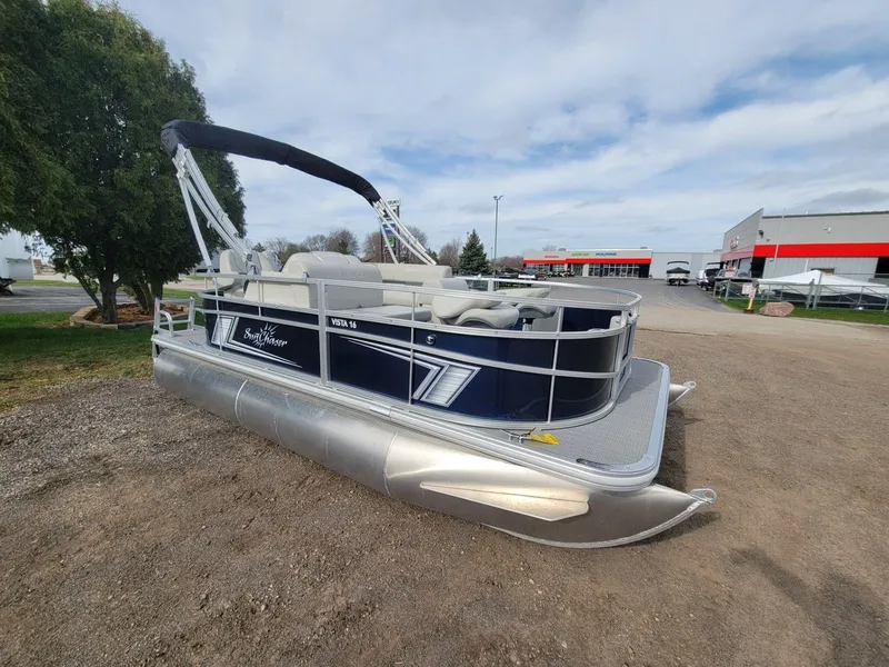 Slide: The Image of 2023 SunChaser Vista 16 Fish pontoon boat parked outdoors on gravel. - 2