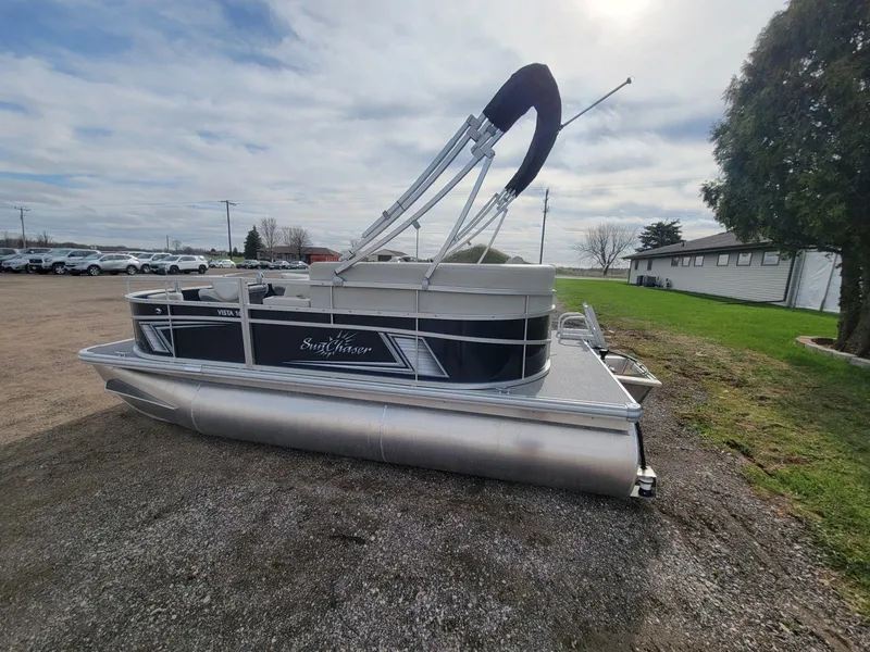 Slide: The Image of 2023 SunChaser Vista 16 Fish pontoon boat parked on gravel lot under cloudy sky. - 5