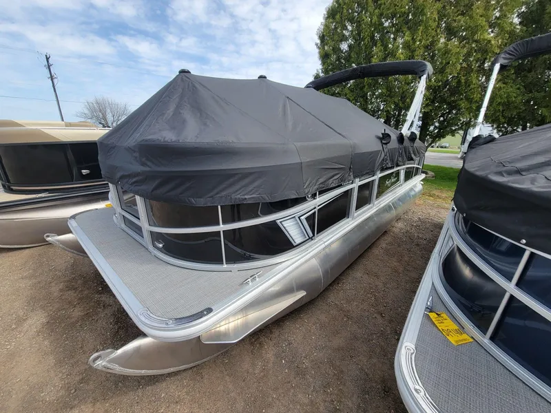 Slide: The Image of 2024 SunChaser Vista 20 CRB pontoon boat with black cover, parked outdoors. - 1