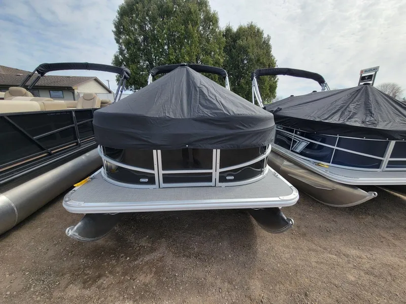 Slide: The Image of 2024 SunChaser Vista 20 CRB pontoon boat with black cover, parked outdoors. - 2