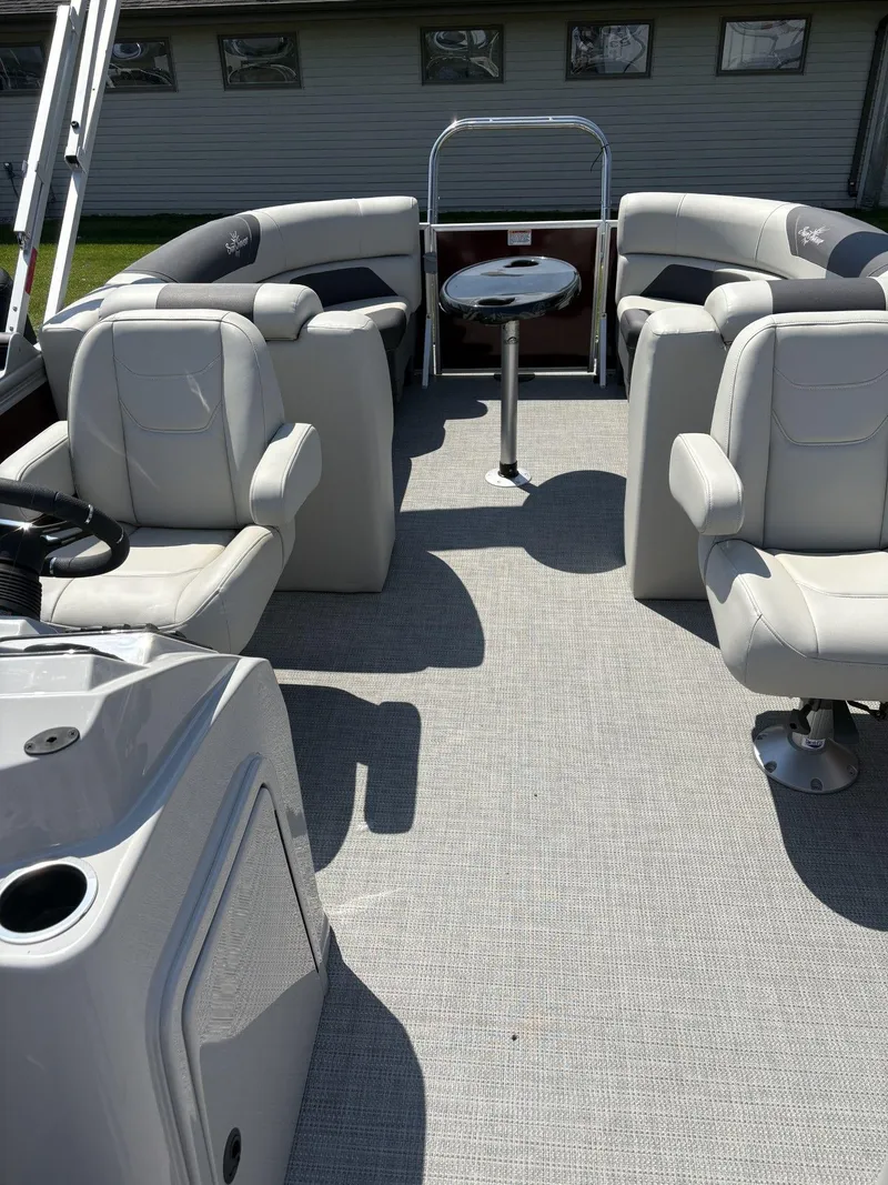 Slide: The Image of 2023 SunChaser Geneva Cruise 22 LR DH pontoon boat interior with plush seating and table. - 12