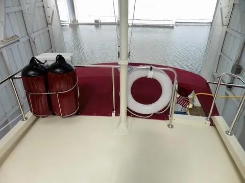 Slide: The Image of 2001 Camano Trawler with life ring and fenders, docked in a covered marina. - 14