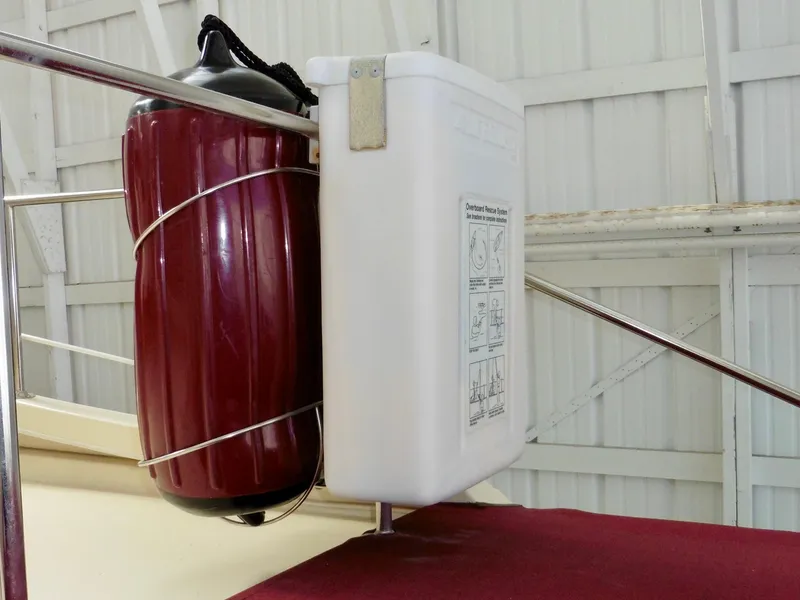 Slide: The Image of 2001 Camano Trawler boat with red fender and white storage container on deck. - 15