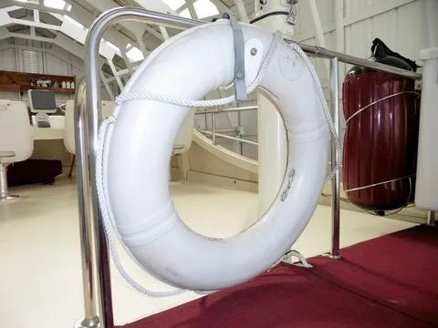 Slide: The Image of Life ring on 2001 Camano Trawler deck, featuring safety equipment and seating area. - 16