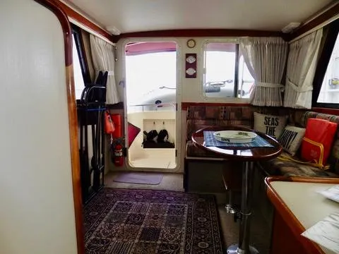 Slide: The Image of Interior of 2001 Camano Trawler with cozy seating, table, and nautical decor. - 19