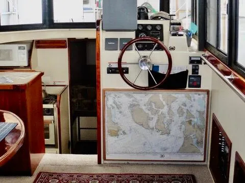 Slide: The Image of 2001 Camano Trawler interior with steering wheel and nautical map. - 20