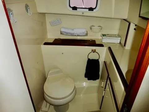 Slide: The Image of 2001 Camano Trawler bathroom with toilet, towel rack, and storage cabinets. - 28