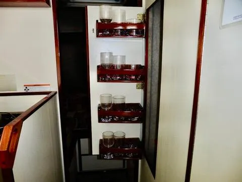 Slide: The Image of Interior of 2001 Camano Trawler with glass holders on wooden shelves. - 33