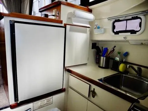 Slide: The Image of 2001 Camano Trawler kitchen with sink, fridge, and storage cabinets. - 34