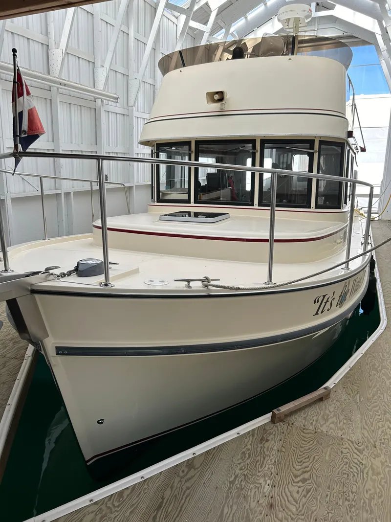 Slide: The Image of 2001 Camano Trawler docked in a covered marina, showcasing its classic design. - 4