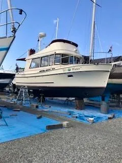 Slide: The Image of 2001 Camano Trawler boat on dry dock, surrounded by blue tarps and equipment. - 40