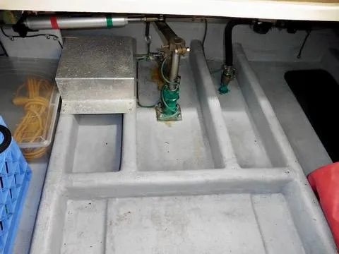 Slide: The Image of Engine compartment of a 2001 Camano Trawler, showing mechanical components and storage space. - 49