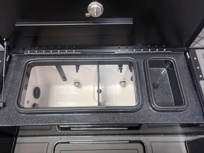 Slide: The Image of 2025 Caymas DV 22 boat livewell with dual compartments and sleek black finish. - 14