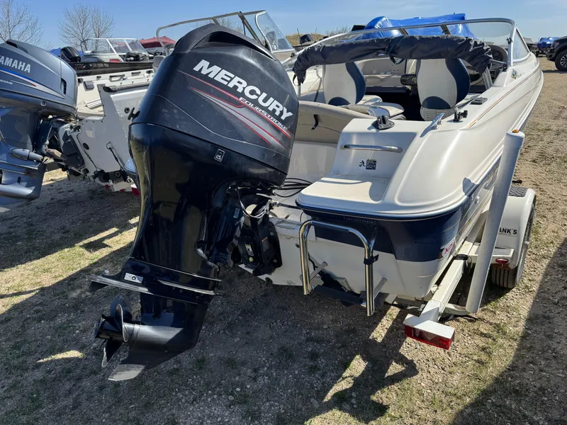 Slide: The Image of 1996 Bayliner 1704 SF boat with Mercury outboard motor, parked on a trailer. - 4