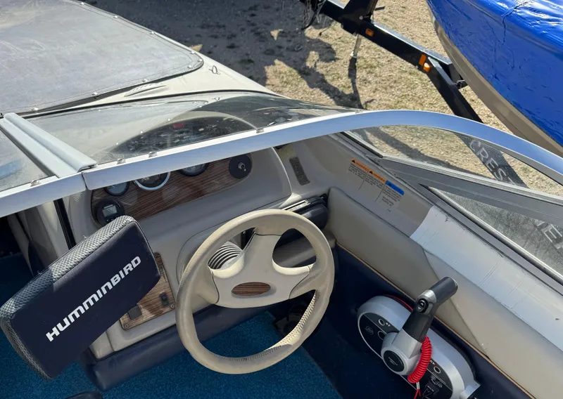 Slide: The Image of 1996 Bayliner 1704 SF boat cockpit with steering wheel and Humminbird fish finder. - 7