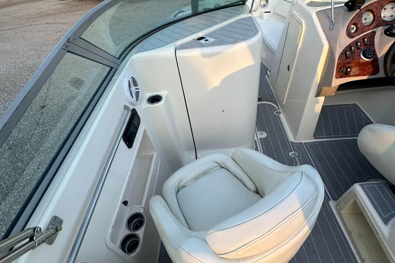 Slide: The Image of 2006 Rinker 262 Captiva Bowrider interior with white seating and dashboard details. - 12