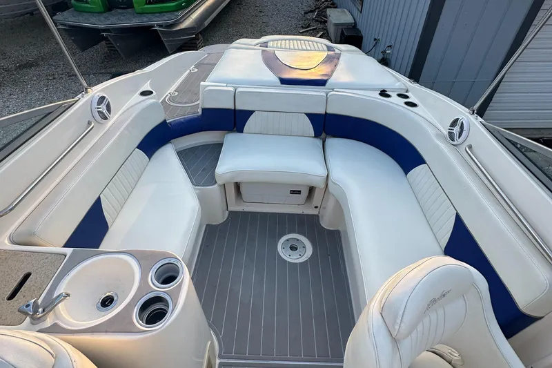 Slide: The Image of 2006 Rinker 262 Captiva Bowrider interior with white and blue seating, cup holders, and deck. - 13