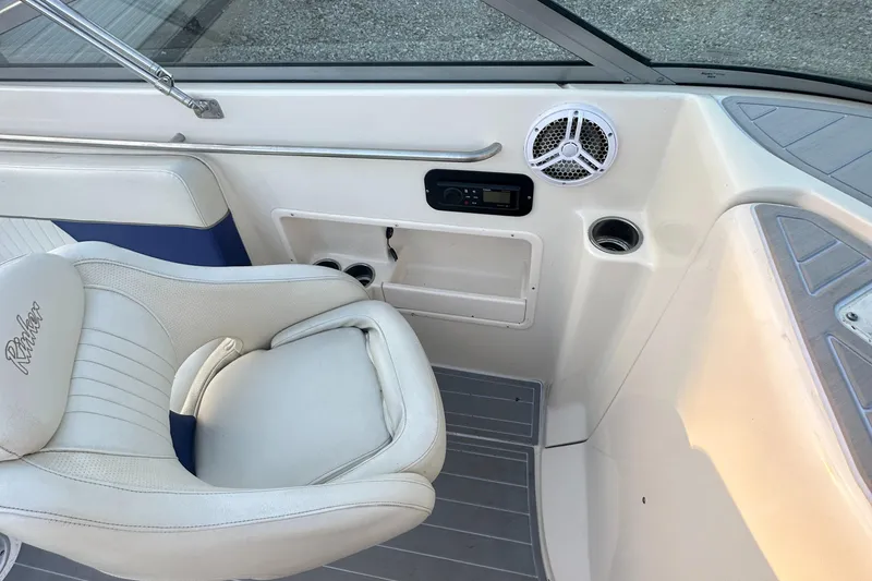 Slide: The Image of 2006 Rinker 262 Captiva Bowrider interior with white seating and speaker system. - 14