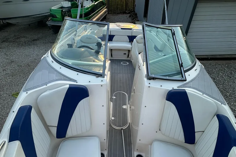Slide: The Image of 2006 Rinker 262 Captiva Bowrider with blue and white seating, docked outdoors. - 19