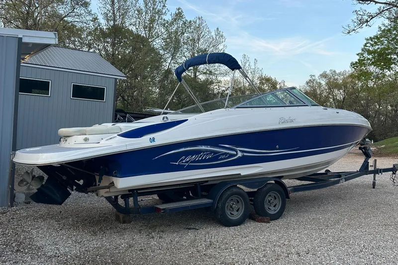 Slide: The Image of 2006 Rinker 262 Captiva Bowrider on trailer, parked outdoors near a building. - 4