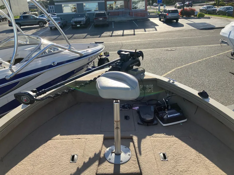 Slide: The Image of 2006 Lowe Fish & Ski FS175 boat interior with seat and trolling motor in parking lot. - 1