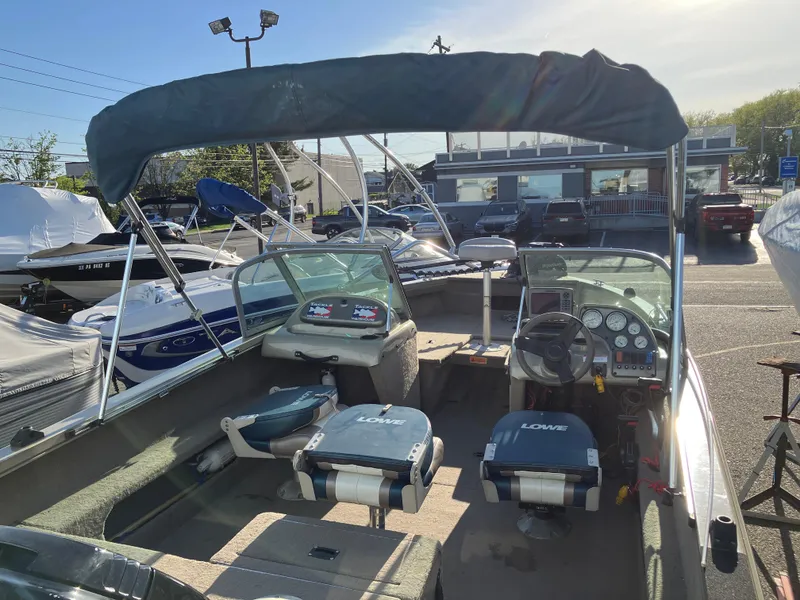 Slide: The Image of 2006 Lowe Fish & Ski FS175 boat with canopy and seating, parked outdoors. - 2