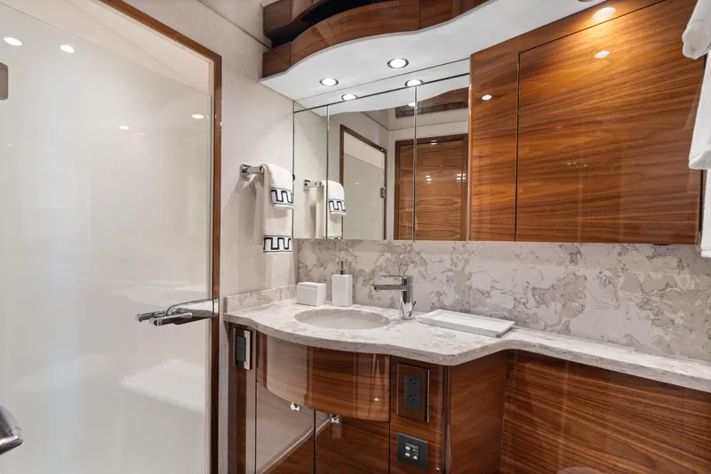 Slide: The Image of Luxurious bathroom in 2025 Viking 58 Convertible yacht with modern wood cabinetry and marble accents. - 10