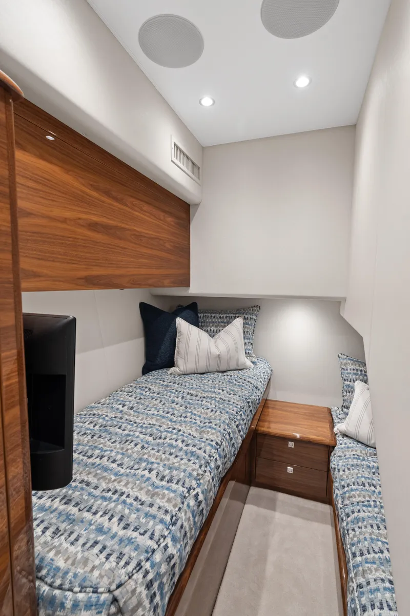 Slide: The Image of 2025 Viking 58 Convertible yacht cabin with twin beds and modern decor. - 21