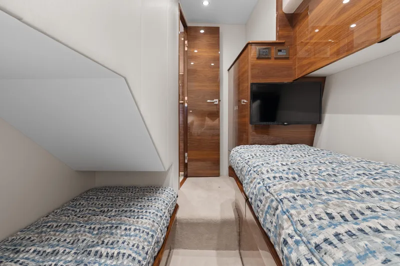 Slide: The Image of 2025 Viking 58 Convertible yacht cabin with twin beds and modern decor. - 23