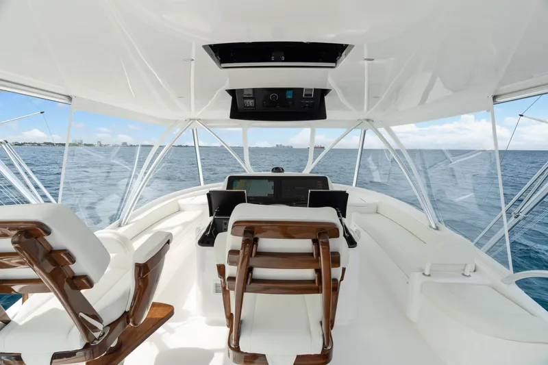 Slide: The Image of 2025 Viking 58 Convertible yacht helm with ocean view, featuring luxurious seating and advanced navigation. - 44