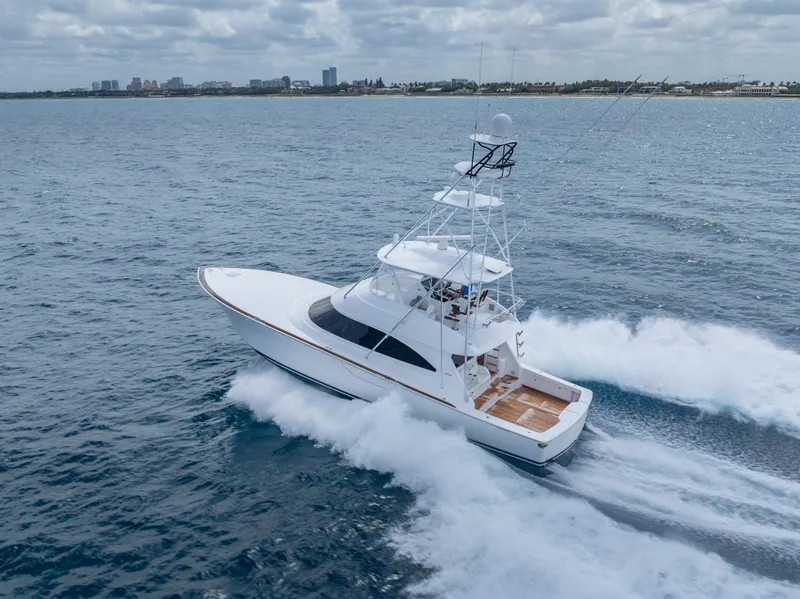 Slide: The Image of 2025 Viking 58 Convertible yacht cruising on open water, near coastline. - 5