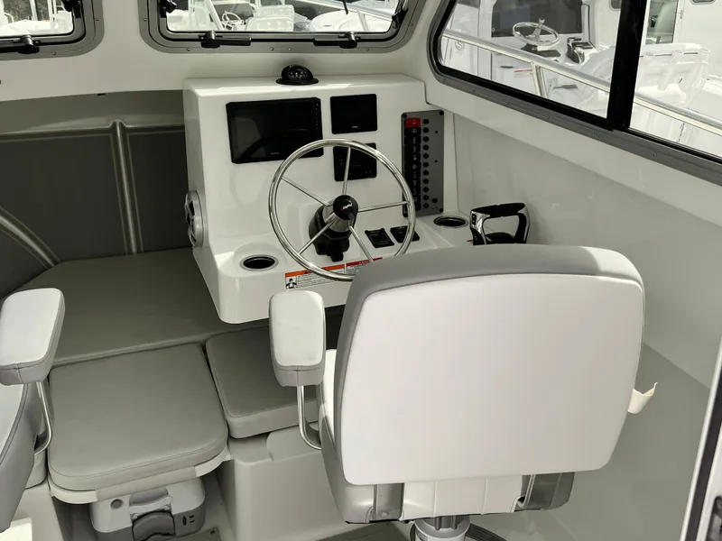 Slide: The Image of Interior of a 2025 Parker 2420 boat, featuring a modern helm and seating area. - 6