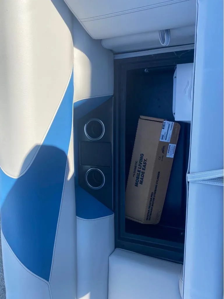 Slide: The Image of 2024 Trifecta 22CL2 LE boat seat storage with cup holders and a box inside. - 17