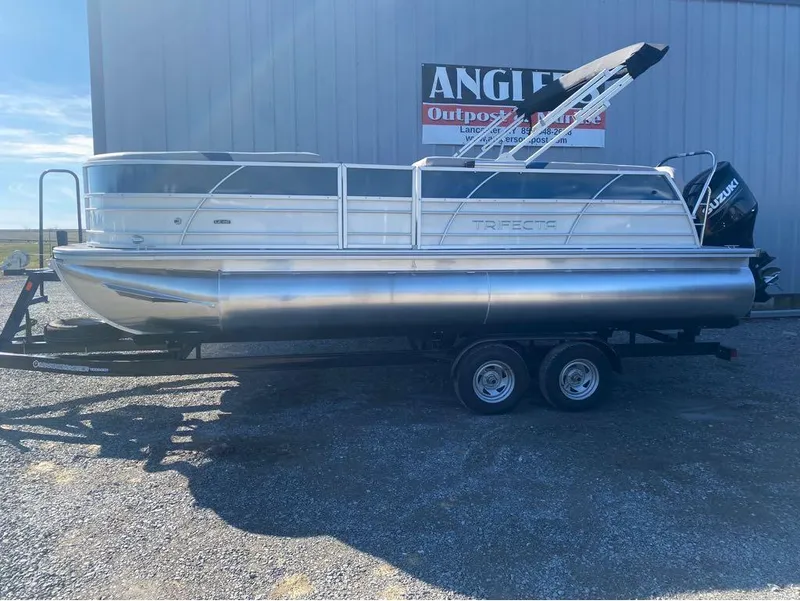 Slide: The Image of 2024 Trifecta 22CL2 LE pontoon boat on trailer, parked outdoors. - 29