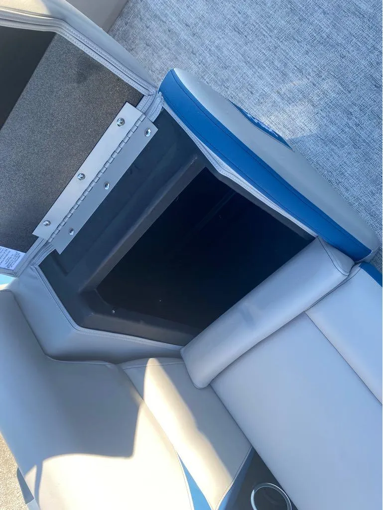 Slide: The Image of 2024 Trifecta 22CL2 LE boat seat storage compartment with blue and gray upholstery. - 9