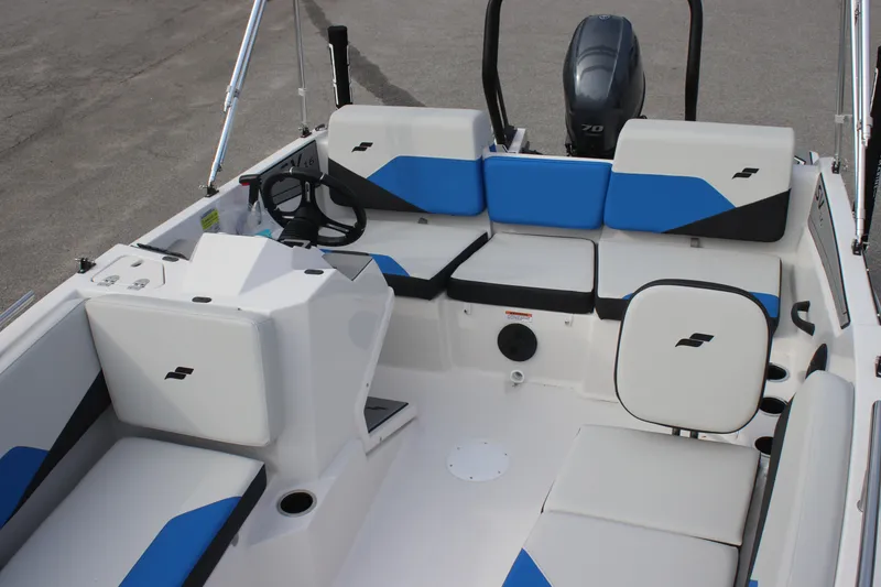 Slide: The Image of 2025 Starcraft SV 16 OB boat interior with blue and white seating and steering console. - 7