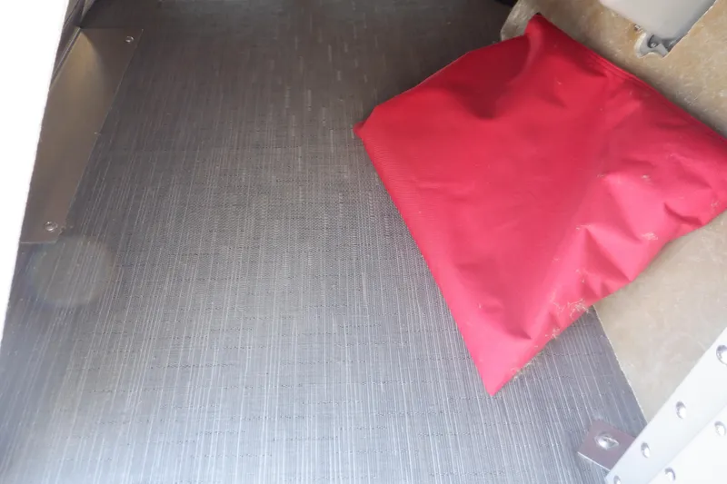 Slide: The Image of 2022 Bennington SX 22 Swingback interior with red cushion on gray flooring. - 23