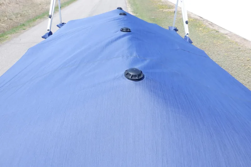 Slide: The Image of 2022 Bennington SX 22 Swingback boat cover in blue, featuring support poles. - 48