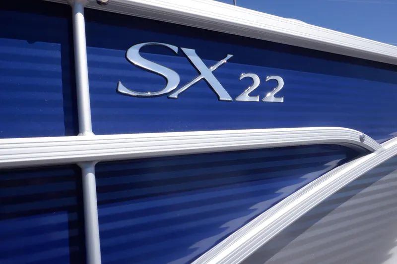 Slide: The Image of 2022 Bennington SX 22 Swingback boat, blue exterior with model name visible. - 7
